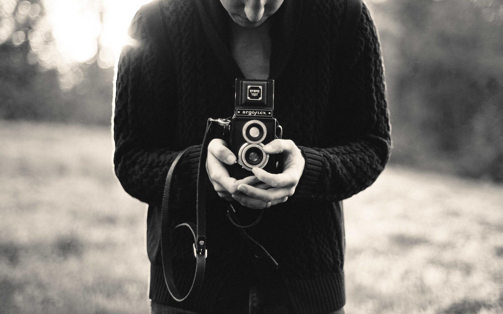Pessoa segurando uma câmera fotográfica antiga